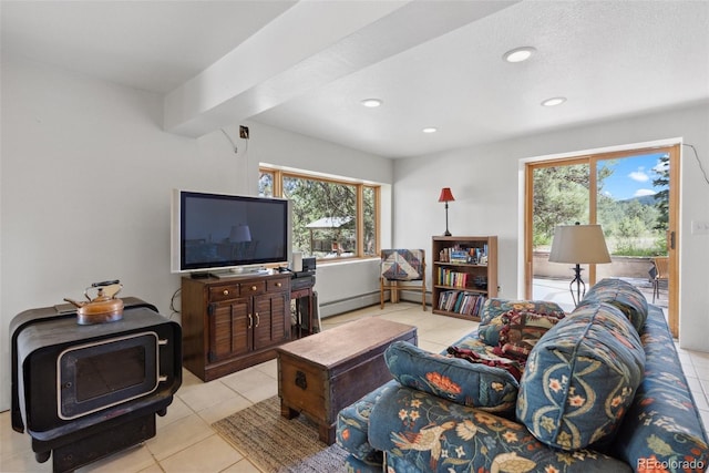 living room with light tile patterned floors, a baseboard heating unit, a wood stove, and recessed lighting