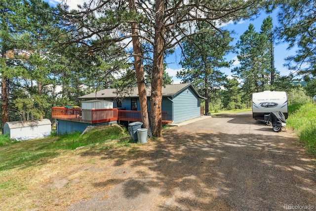 exterior space with dirt driveway and a deck