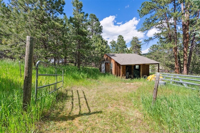 view of yard with fence and an outbuilding