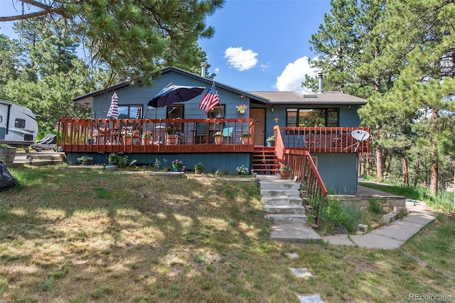 view of front facade featuring a deck, stairway, and a front lawn