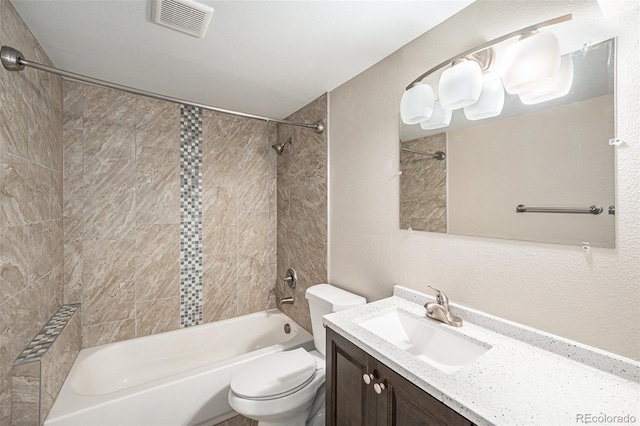 full bathroom with a textured wall, toilet, bathing tub / shower combination, vanity, and visible vents