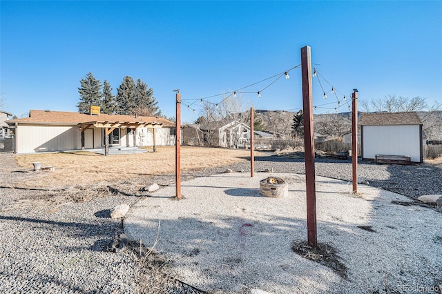 view of yard featuring an outbuilding, a storage unit, a patio area, and fence