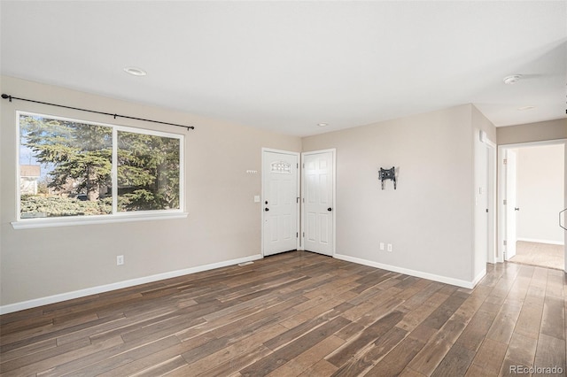 empty room featuring baseboards and wood finished floors