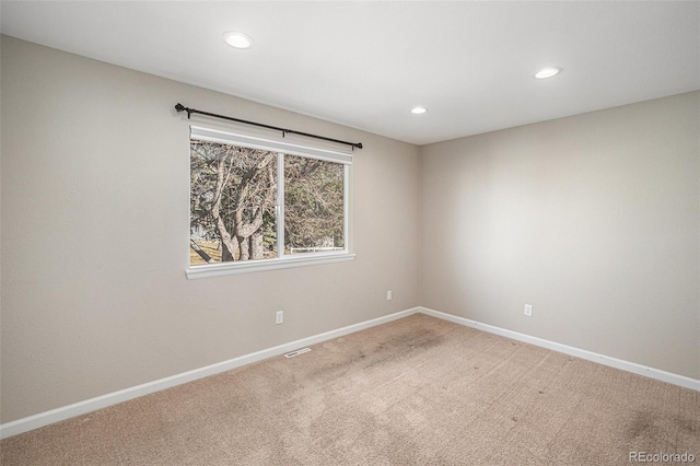 empty room with carpet, visible vents, baseboards, and recessed lighting