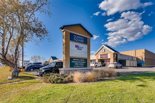 exterior space featuring a lawn and uncovered parking