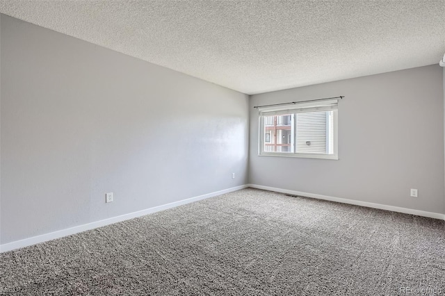 unfurnished room with carpet floors and a textured ceiling