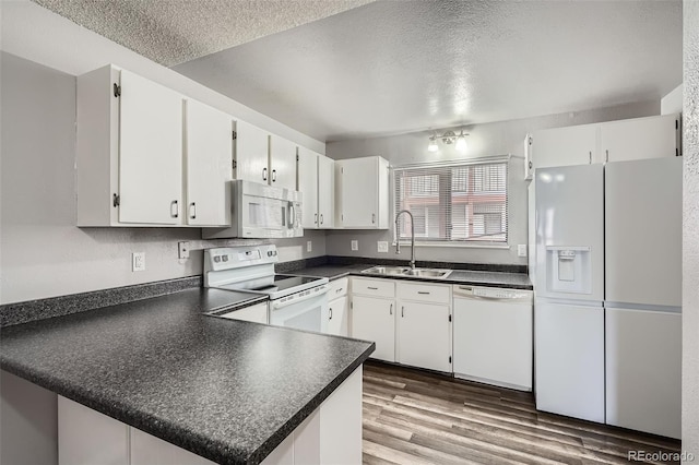 kitchen featuring white cabinetry, sink, white appliances, kitchen peninsula, and a textured ceiling