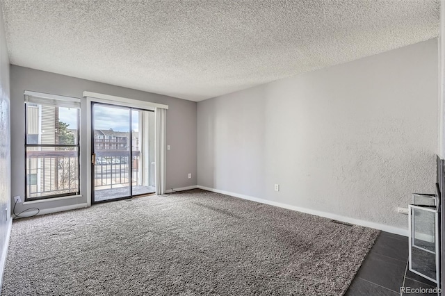 carpeted spare room featuring a textured ceiling