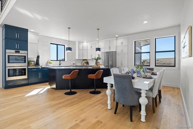 dining area featuring sink and light hardwood / wood-style floors