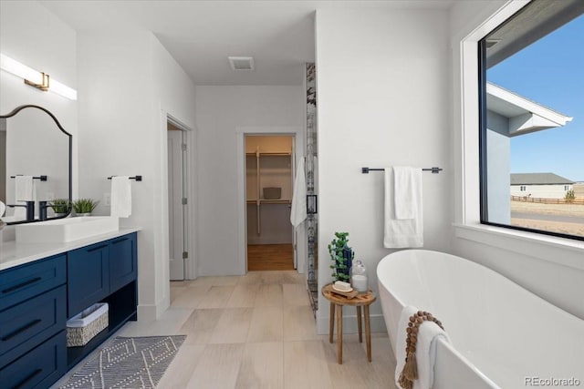 bathroom with a washtub and vanity