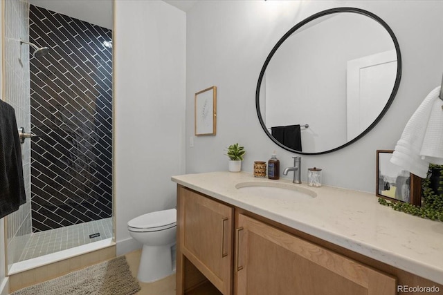 bathroom featuring tiled shower, vanity, and toilet