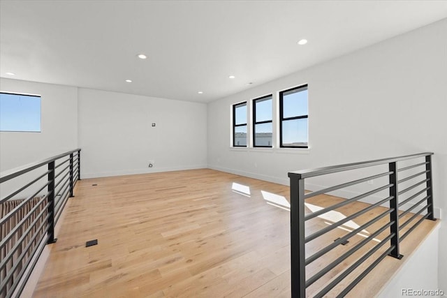 spare room featuring a healthy amount of sunlight and light hardwood / wood-style floors