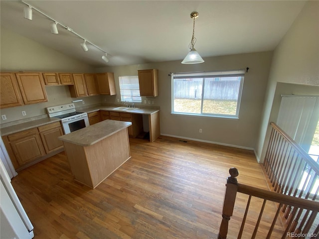 kitchen featuring light brown cabinetry, electric range, light countertops, and vaulted ceiling