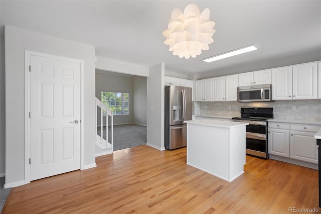 kitchen featuring white cabinets, light hardwood / wood-style flooring, appliances with stainless steel finishes, and a center island