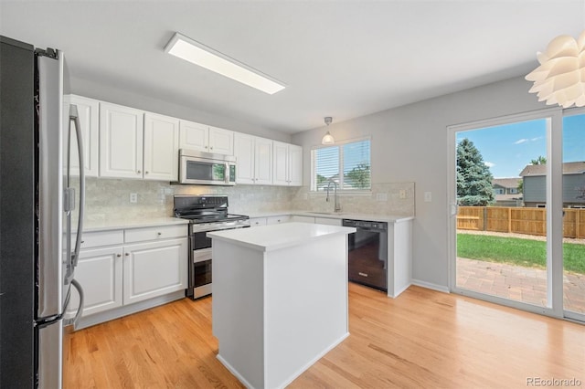 kitchen with white cabinets, light hardwood / wood-style floors, and stainless steel appliances