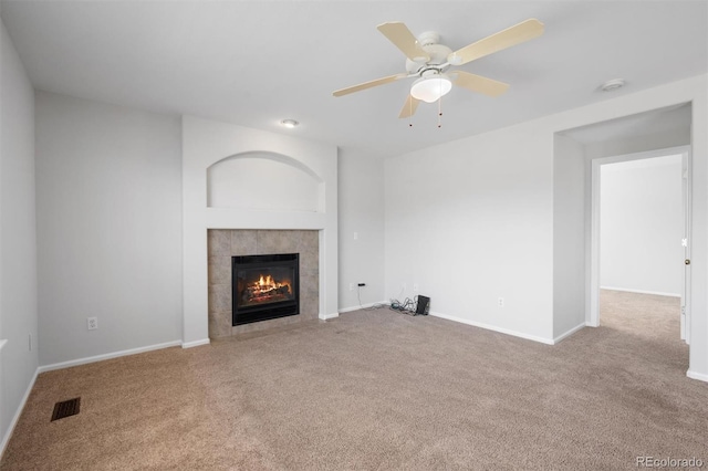 unfurnished living room with a fireplace, ceiling fan, and light colored carpet