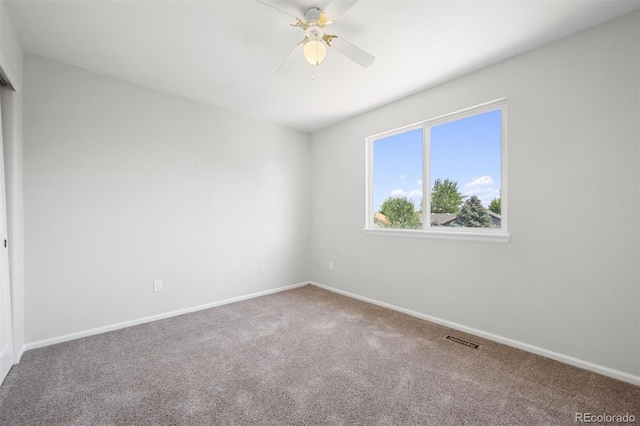 carpeted spare room featuring ceiling fan