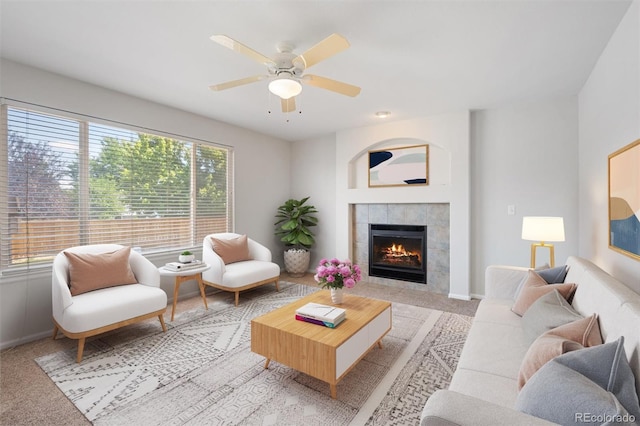 carpeted living room featuring ceiling fan and a fireplace