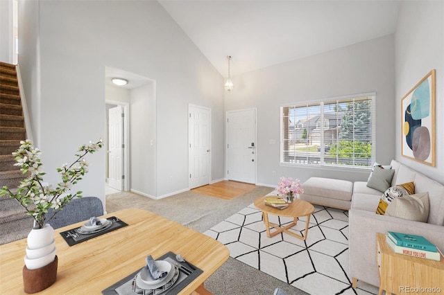 living room featuring high vaulted ceiling and light hardwood / wood-style flooring