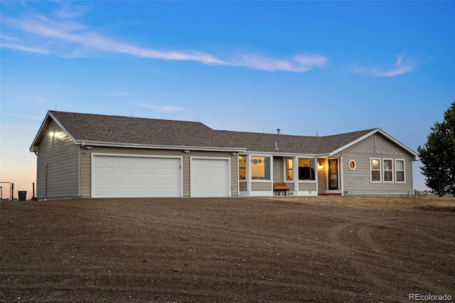 single story home featuring roof with shingles, driveway, and an attached garage