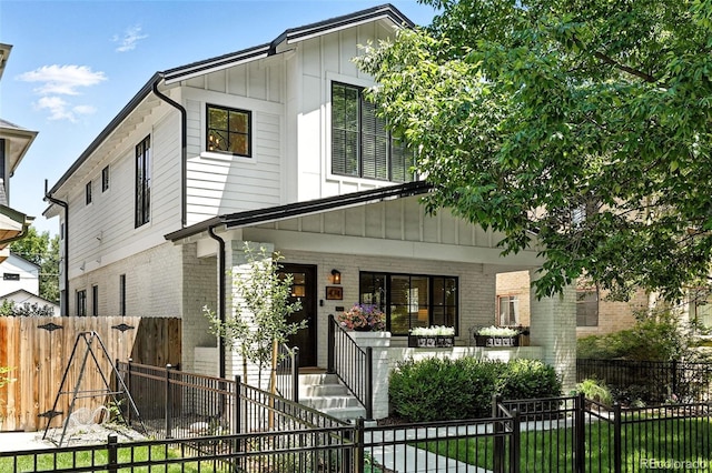 474 S Vine St, Denver, CO 80209 - view of front facade with covered porch, board and batten siding, a gate, and brick siding