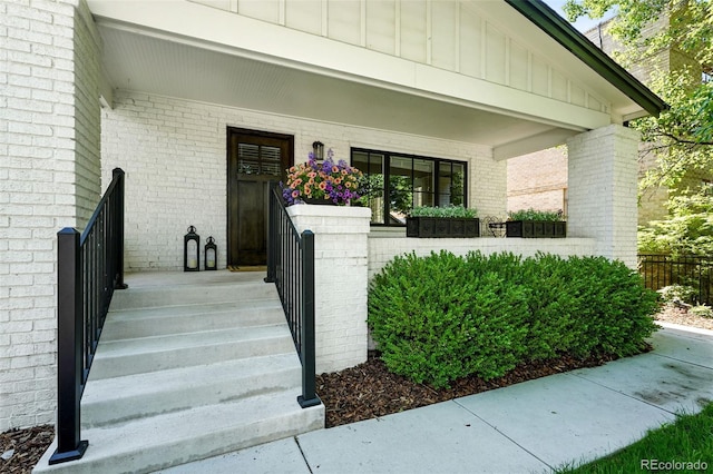 474 S Vine St, Denver, CO 80209 - doorway to property with board and batten siding, brick siding, and covered porch