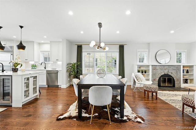 474 S Vine St, Denver, CO 80209 - dining space featuring beverage cooler, a chandelier, dark wood-style flooring, recessed lighting, and a glass covered fireplace