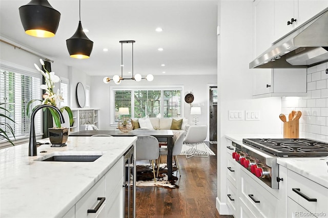 474 S Vine St, Denver, CO 80209 - kitchen with under cabinet range hood, open floor plan, stainless steel gas stovetop, dark wood-type flooring, and recessed lighting