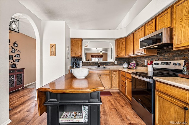 kitchen featuring appliances with stainless steel finishes, sink, backsplash, and light hardwood / wood-style floors