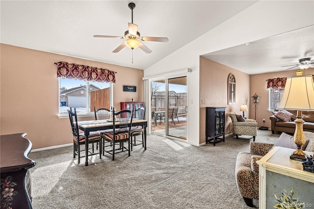 dining area featuring ceiling fan, lofted ceiling, carpet, and a textured ceiling