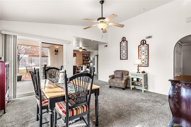 carpeted dining space with vaulted ceiling and ceiling fan