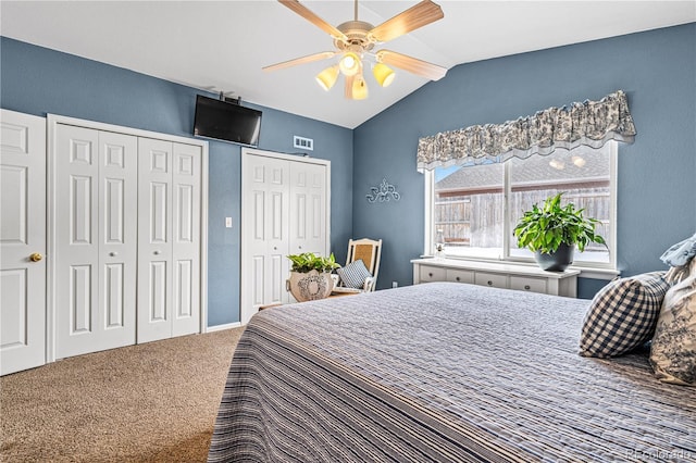 carpeted bedroom with lofted ceiling, ceiling fan, and multiple closets