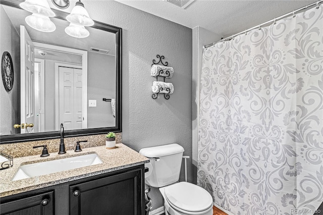 bathroom featuring vanity, toilet, and a textured ceiling