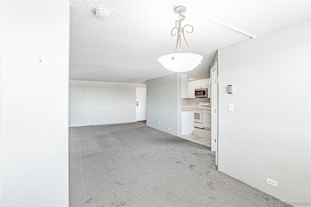 2225 Buchtel Blvd Unit 1005, Denver, CO 80210 - spare room featuring light carpet, a smoke detector, and a textured ceiling