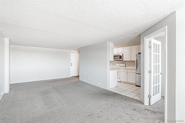 2225 Buchtel Blvd Unit 1005, Denver, CO 80210 - unfurnished living room with light carpet, a textured ceiling, and light tile patterned flooring