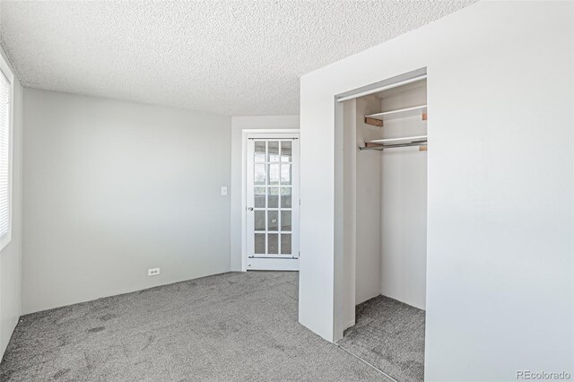 2225 Buchtel Blvd Unit 1005, Denver, CO 80210 - unfurnished bedroom featuring carpet, a closet, and a textured ceiling