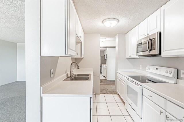2225 Buchtel Blvd Unit 1005, Denver, CO 80210 - kitchen featuring electric stove, stainless steel microwave, a textured ceiling, a sink, and light carpet