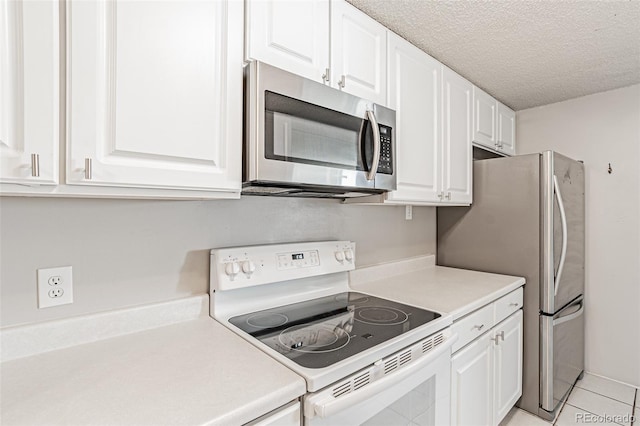 2225 Buchtel Blvd Unit 1005, Denver, CO 80210 - kitchen with stainless steel appliances, white cabinets, light countertops, a textured ceiling, and light tile patterned flooring