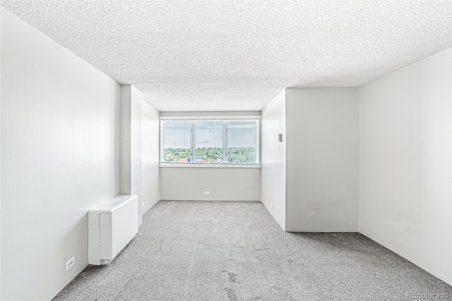 2225 Buchtel Blvd Unit 1005, Denver, CO 80210 - carpeted empty room with radiator and a textured ceiling