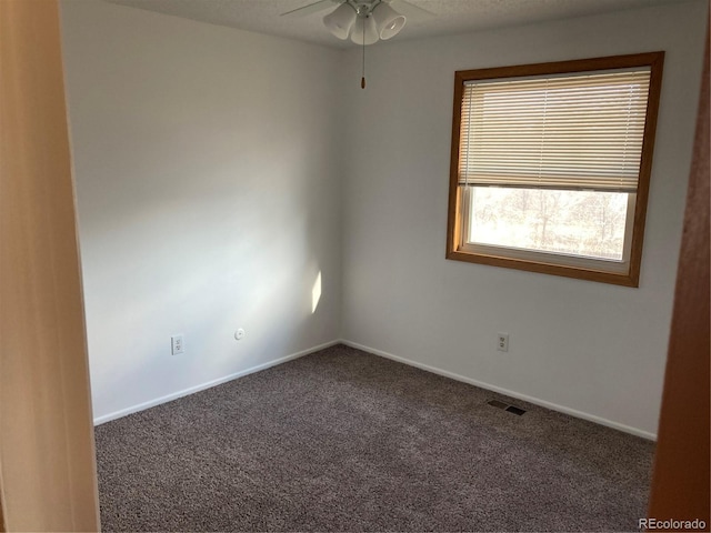 unfurnished room with carpet, visible vents, baseboards, and ceiling fan