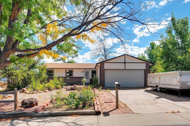 single story home featuring driveway, an attached garage, and brick siding