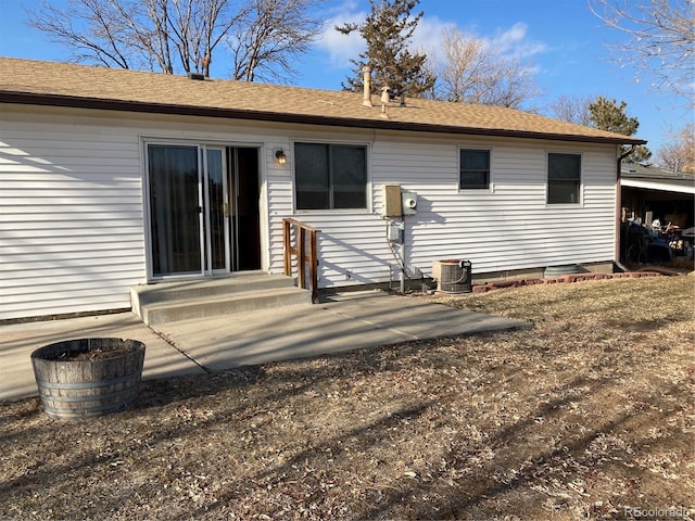 rear view of house featuring entry steps, a patio, central AC, and roof with shingles