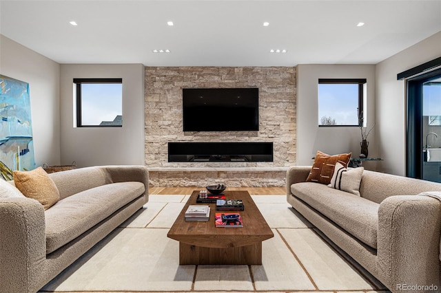 living room with a fireplace, light hardwood / wood-style flooring, and a healthy amount of sunlight