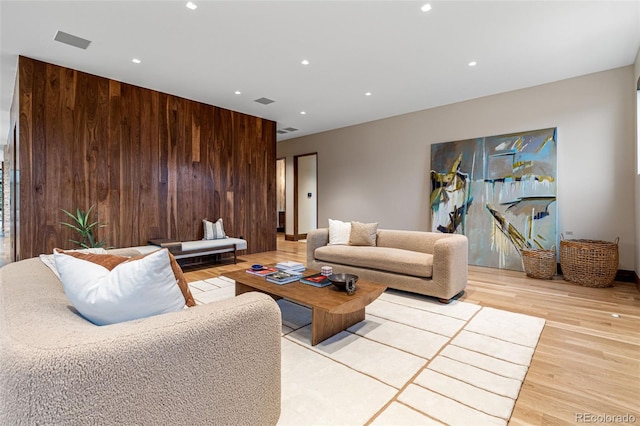 living room featuring light hardwood / wood-style floors and wooden walls