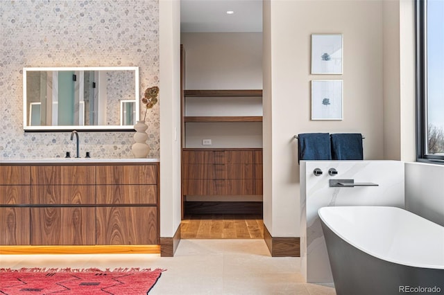 bathroom featuring a bath, vanity, and hardwood / wood-style flooring