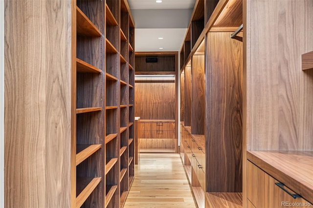 walk in closet with light hardwood / wood-style flooring