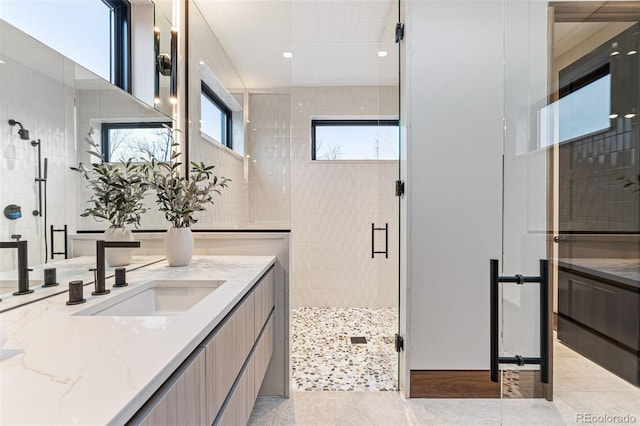 bathroom featuring vanity, an enclosed shower, and tile walls