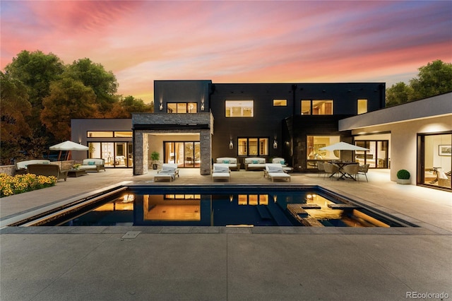 back house at dusk with a patio