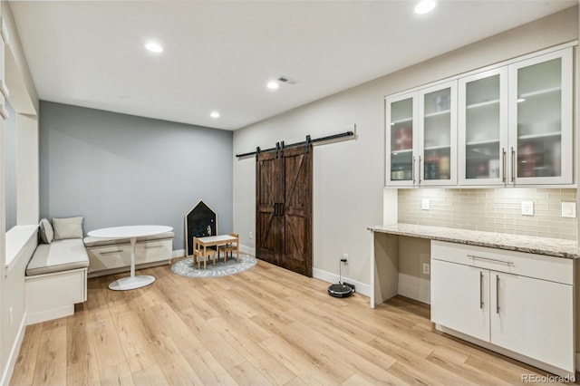 9244 E 37th Ave, Denver, CO 80238 - living area featuring a barn door, light wood-style flooring, and recessed lighting