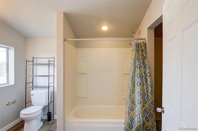 bathroom featuring hardwood / wood-style flooring, shower / bath combination with curtain, and toilet